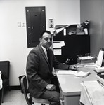 Man sitting at desk by John Foster